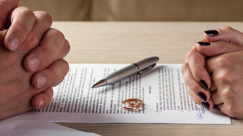 Divorcing-Couple's-Hands-Over-Paperwork-Discussing-Divorce-FAQ