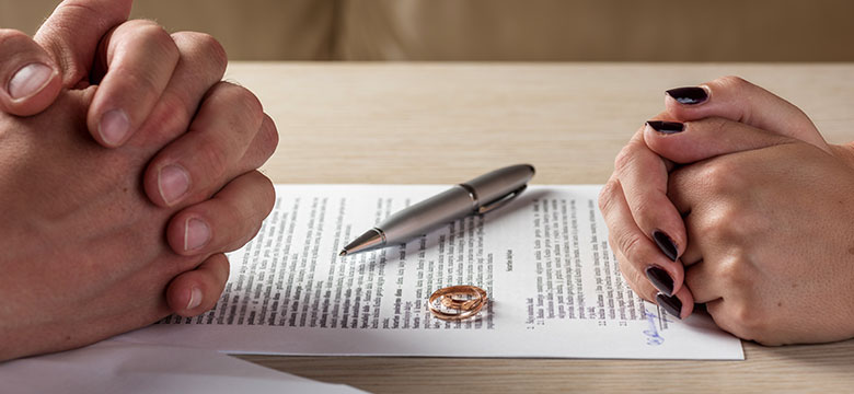 Divorcing-Couple's-Hands-Over-Paperwork-Discussing-Divorce-FAQ